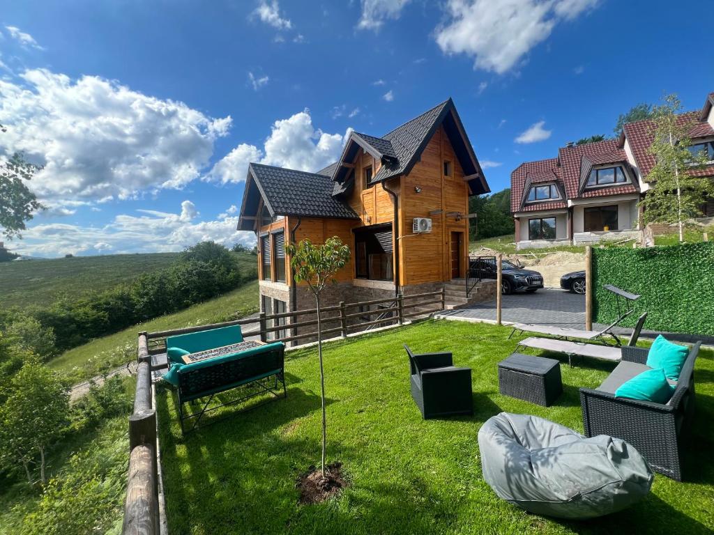 una casa en una colina con un patio en LUX PINE house en Zlatibor