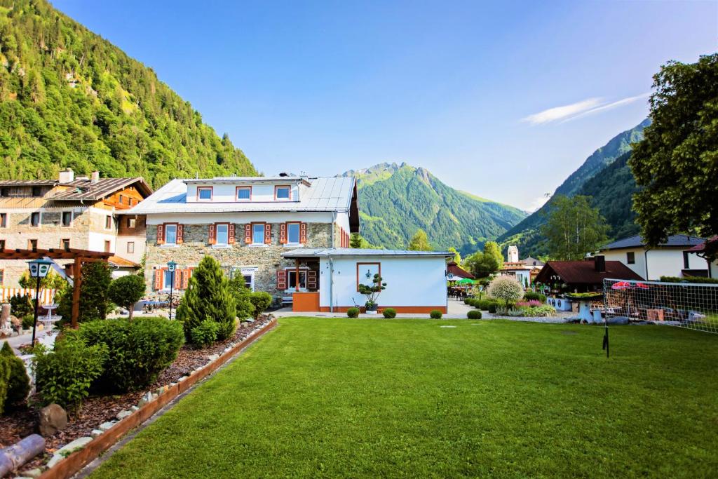dom z trawnikiem przed górą w obiekcie IMBACHHORN Pension in den Alpen w mieście Fusch an der Großglocknerstraße