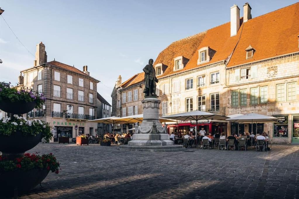 a statue in the middle of a street with buildings at Frans dorpshuisje Maison Gerard in Bussières-lès-Belmont