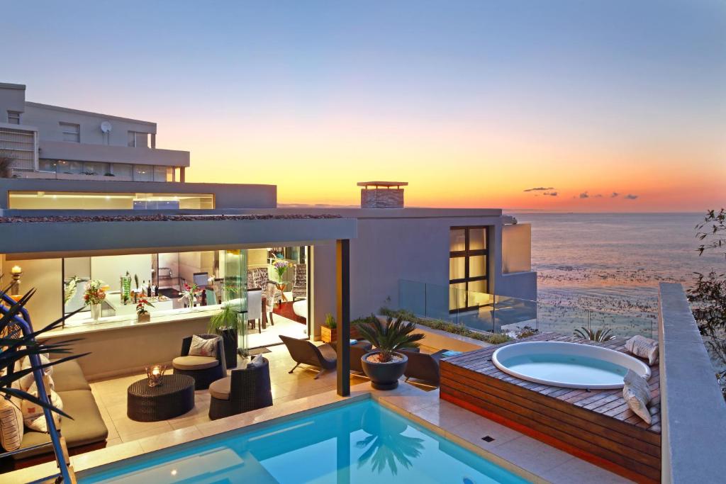 a house on the beach with a swimming pool at Azamare Guest House in Cape Town
