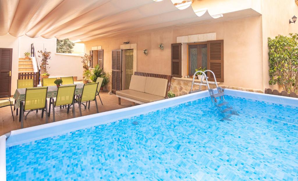 einen Pool mit einem Tisch und Stühlen neben einem Haus in der Unterkunft Casa Ancla 011 by Mallorca Charme in Muro