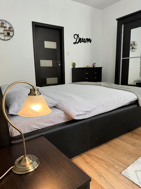 a bedroom with a bed with a table and a lamp at Ada's Luxury Apartment - Old City in Braşov