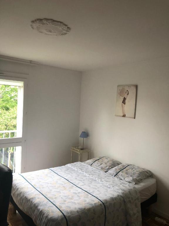 Maison du bonheur في فيليرز سور مارن: غرفة نوم بها سرير ونافذة