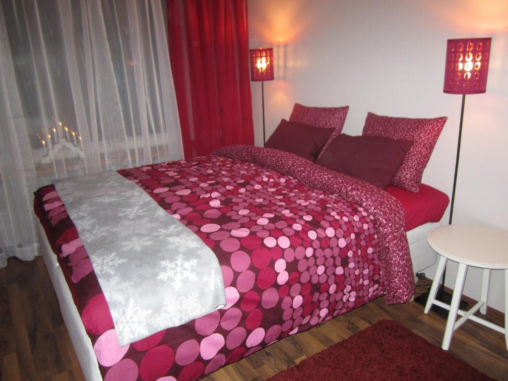 a bedroom with a large bed with pink polka dots at Piriko Piccolo Apartment in Rovaniemi