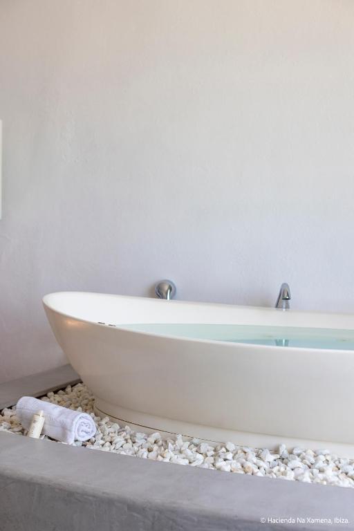 a white bath tub sitting on a counter in a bathroom at Hacienda Na Xamena, Ibiza in Na Xamena