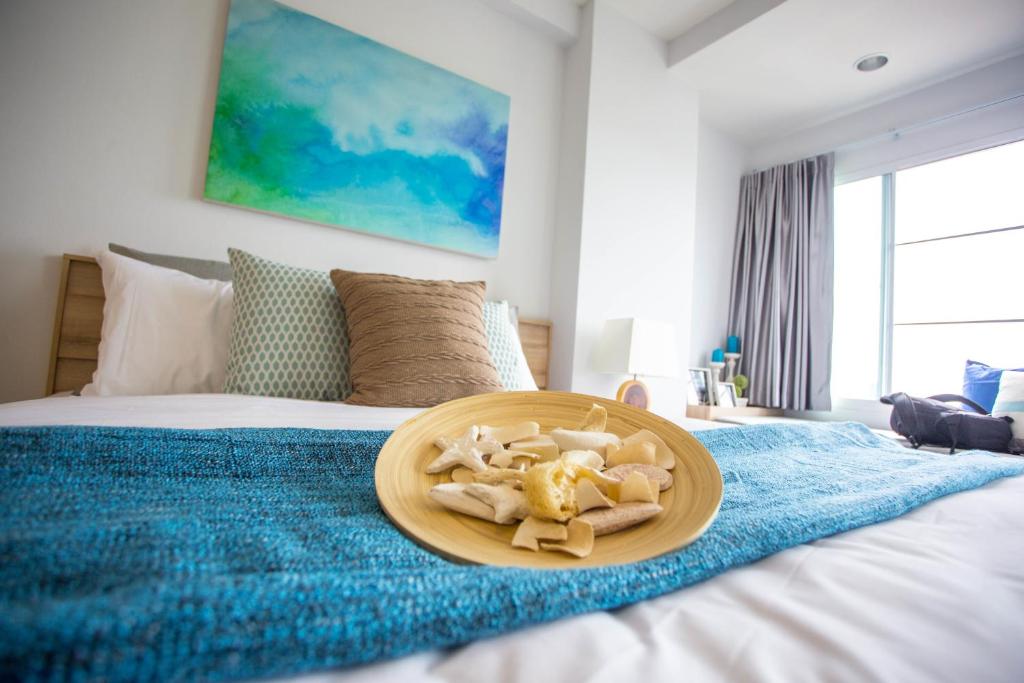 Des Res Hotel and Residence في بانغنا: صحن من الطعام موجود فوق السرير