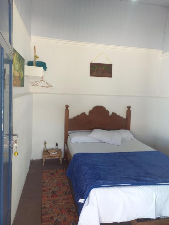 Schlafzimmer mit einem Bett mit blauer Decke in der Unterkunft Pousada Espaço Cosmos in Águas da Prata