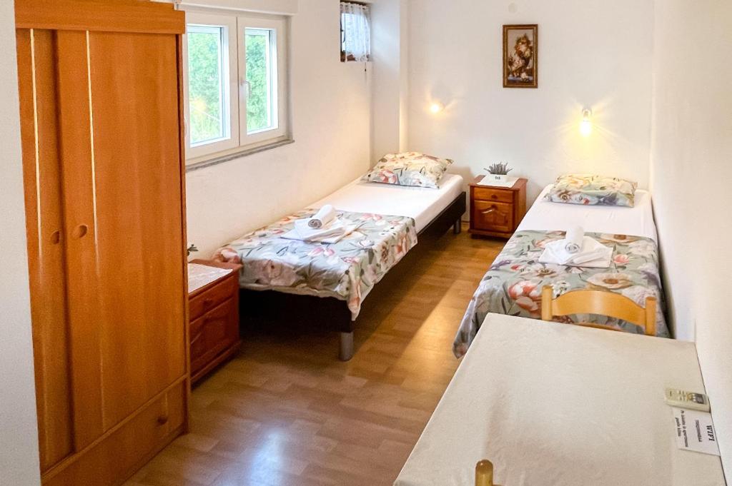 um pequeno quarto com 2 camas e uma janela em Apartmani Danica em Orebić