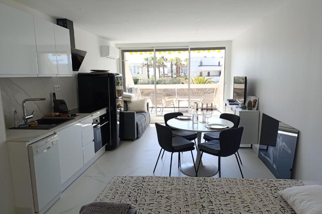 une cuisine avec une table et des chaises dans une pièce dans l'établissement Naturiste Cap d'Agde Héliopolis O 11, au Cap d'Agde