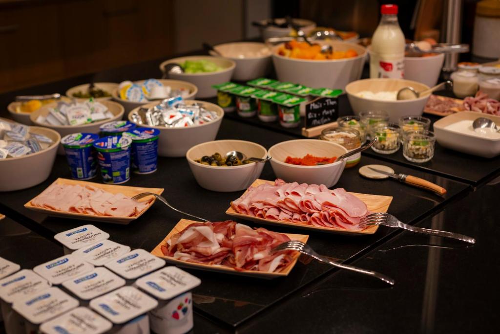 a table with many plates of food on it at Mondorf Parc Hotel & Spa in Mondorf-les-Bains