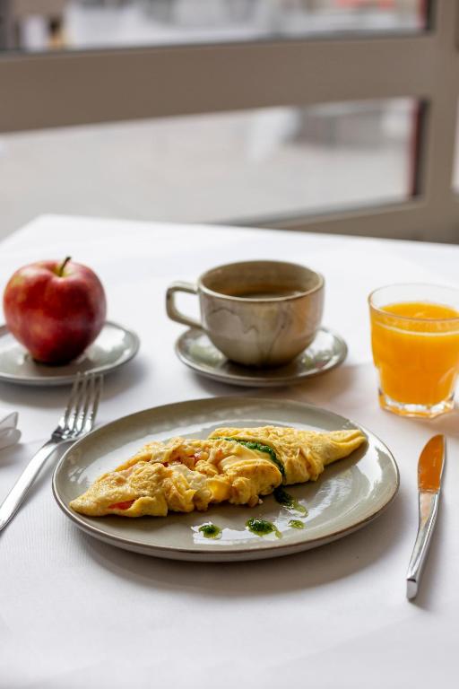 an omelet on a plate on a table with an apple at Mondorf Parc Hotel & Spa in Mondorf-les-Bains