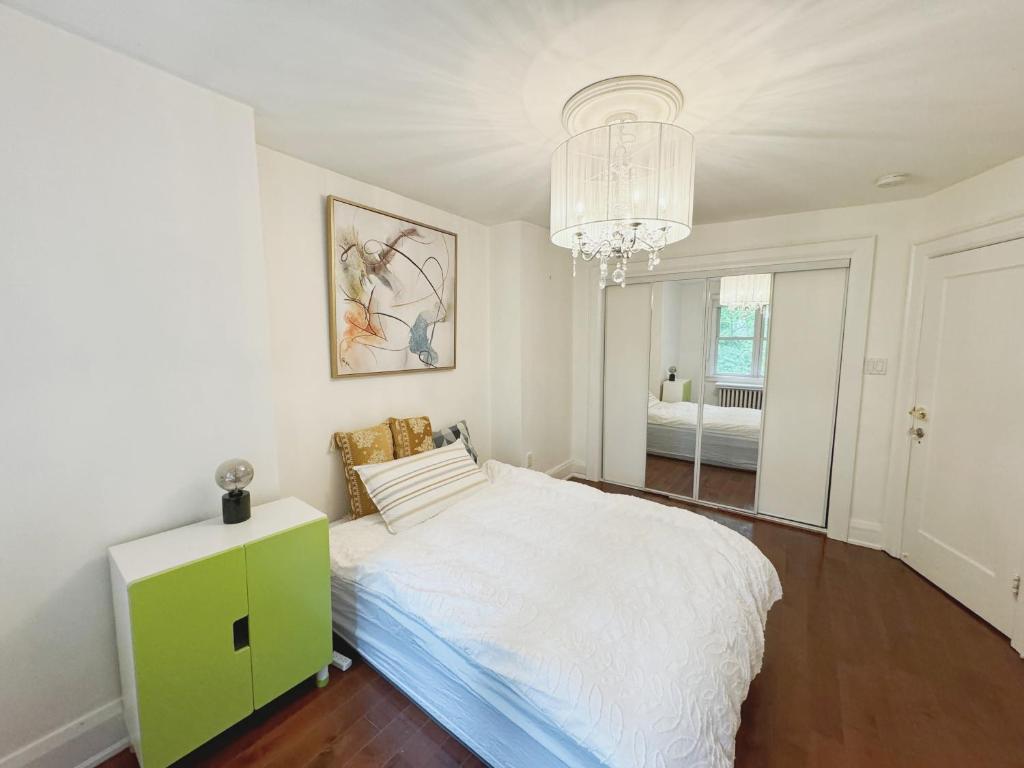 a white bedroom with a bed and a chandelier at toronto midtown luxury double bed in Toronto