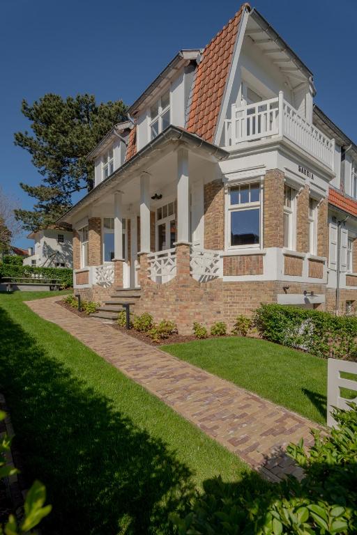 a large brick house with a pathway in front of it at Villa-Sabbia in Koksijde