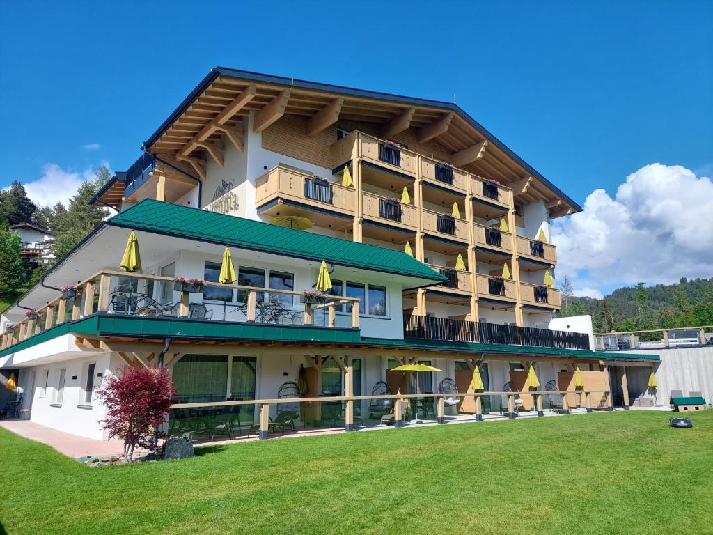 ein großes Gebäude mit Rasen davor in der Unterkunft Das Aparthotel Olympia Tirol in Seefeld in Tirol
