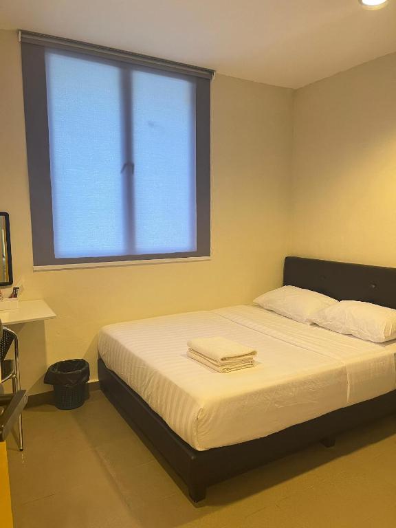 a bed in a room with a large window at Jb Sojourn in Skudai