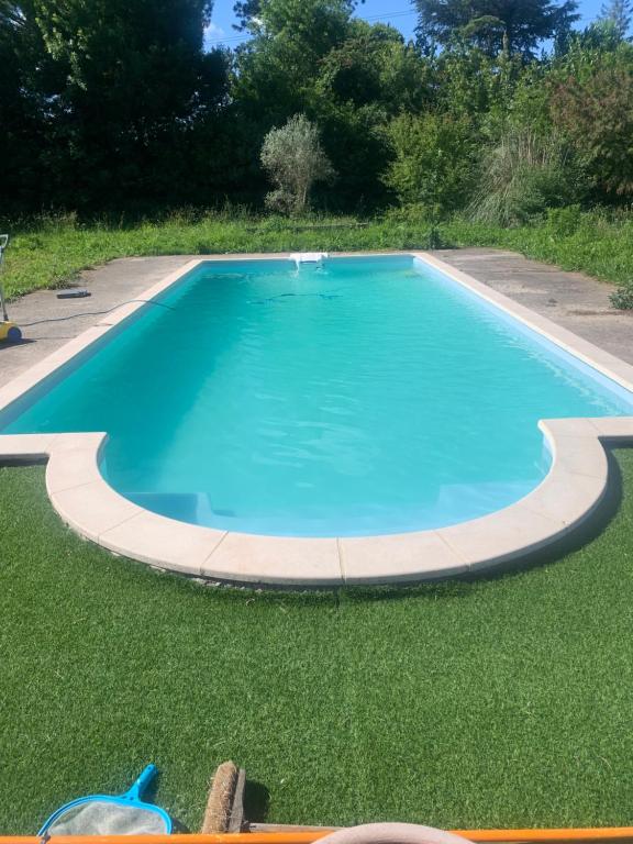 une grande piscine avec une pelouse verdoyante dans l'établissement Villa avignon, à Avignon