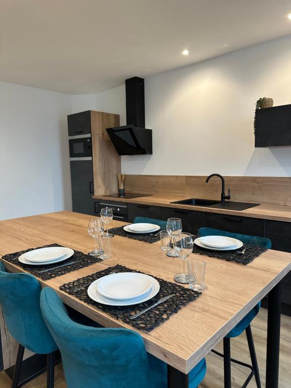 a table with plates and glasses on it in a kitchen at Appartement de la gare in Remiremont