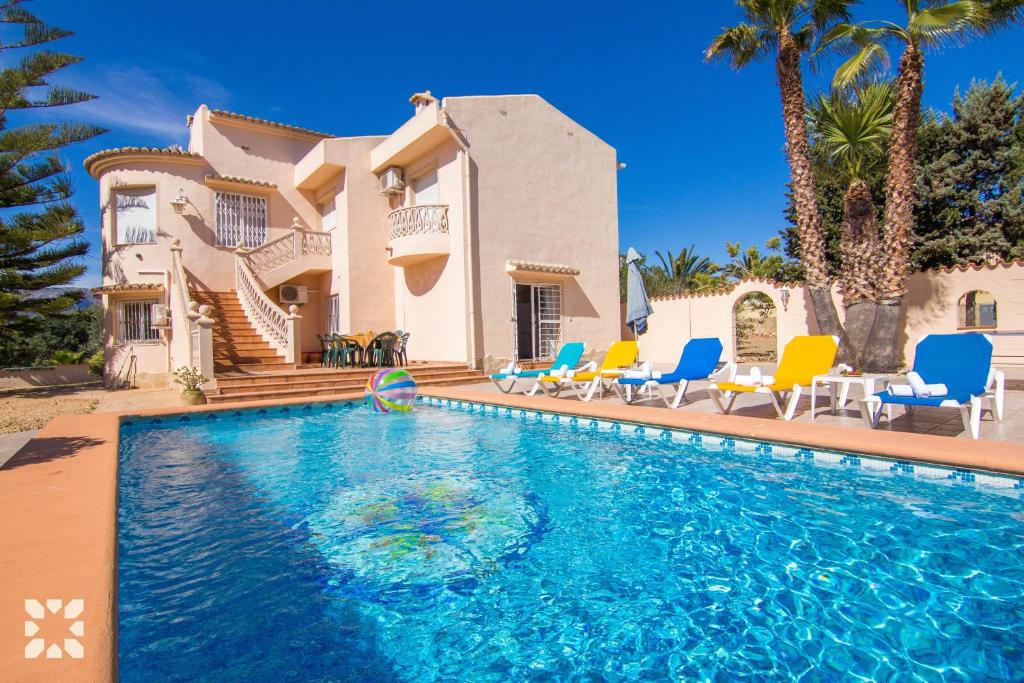 a villa with a swimming pool in front of a house at Villa Luna Feliz by Abahana Villas in Calpe