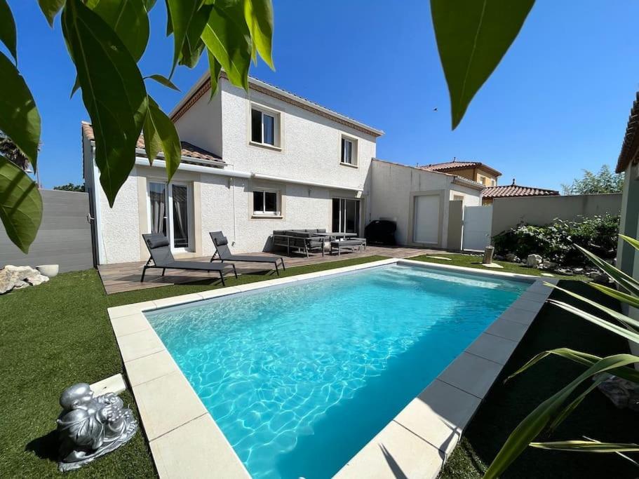 une piscine devant une maison dans l'établissement Villa climatisée avec piscine, à Baillargues