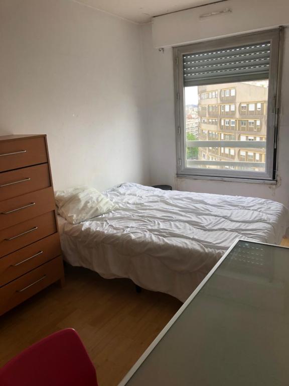 a bedroom with a bed and a dresser and a window at A Boulogne une chambre meublée dans appartement partagé 5 mn du métro et tram in Boulogne-Billancourt