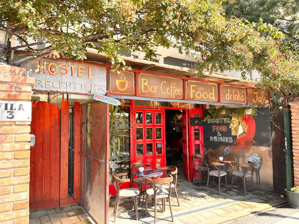 a restaurant with tables and chairs outside of it at Divina Hostel in Tirana