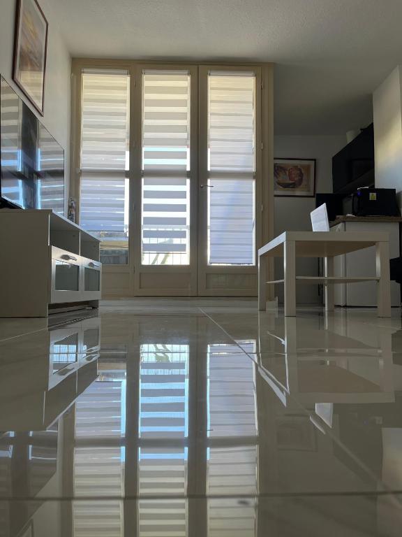 un salon avec des sols et des fenêtres blancs dans l'établissement Studio en résidence avec parking, au Cap d'Agde