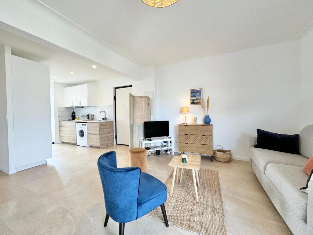 un salon avec un canapé et une chaise bleue dans l'établissement Très bel appartement tout confort à Juan les Pins, à Antibes