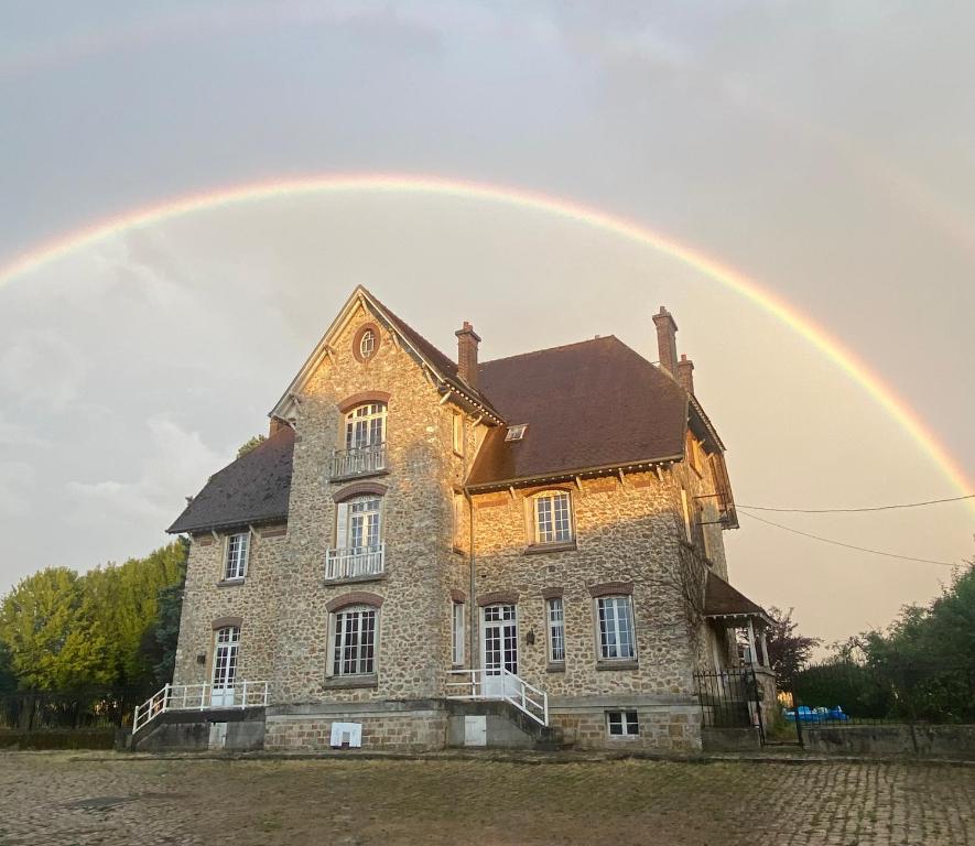 un arc-en-ciel sur une vieille maison avec dans l'établissement La Demeure de Marcy, à La Ferté-sous-Jouarre