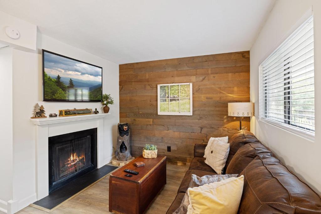 a living room with a couch and a fireplace at Beary Convenient is a Newly Renovated King Suite Condo in the heart of Gatlinburg with pools in Gatlinburg