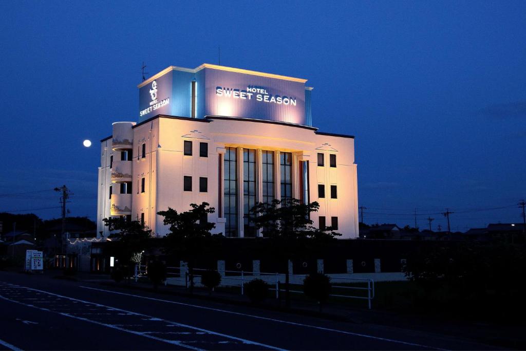 un edificio bianco con un cartello sopra di hotel SWEET SEASON a Hashima