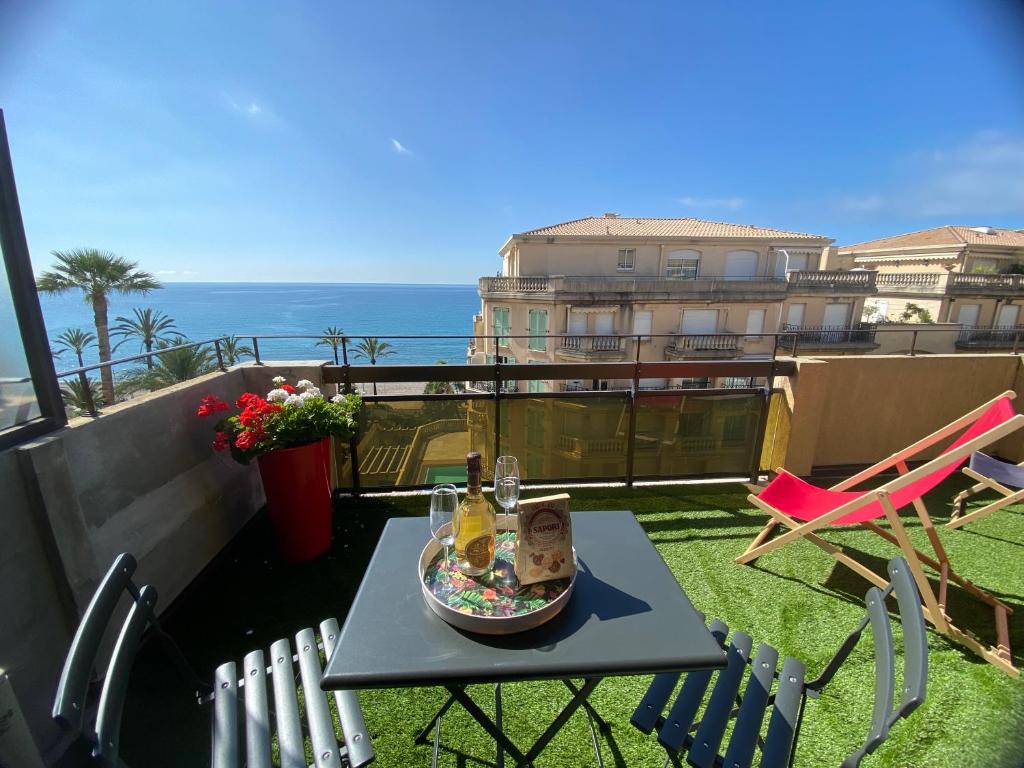 - une table sur un balcon avec vue sur l'océan dans l'établissement The view-Centre- Clim -Parking-vue mer-plage, à Menton