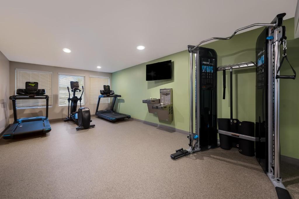 einen Fitnessraum mit mehreren Laufbändern in einem Zimmer in der Unterkunft WoodSpring Suites Winston-Salem near Hanes Mall in Winston-Salem