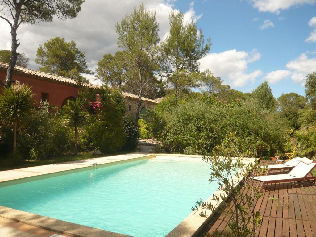 ein Schwimmbad in einem Hof neben einem Haus in der Unterkunft L'Ostal du Pic St Loup in Saint-Jean-de-Cuculles