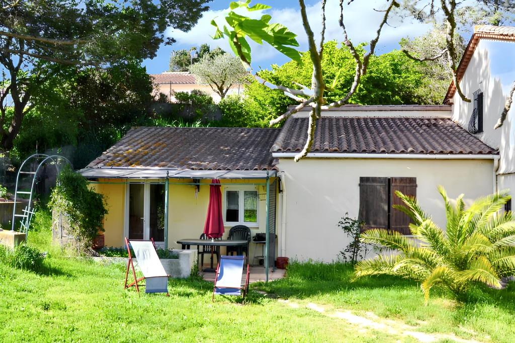 ein kleines weißes Haus mit einem Tisch im Hof in der Unterkunft Maison de 2 chambres avec jardin clos et wifi a Berriac in Berriac