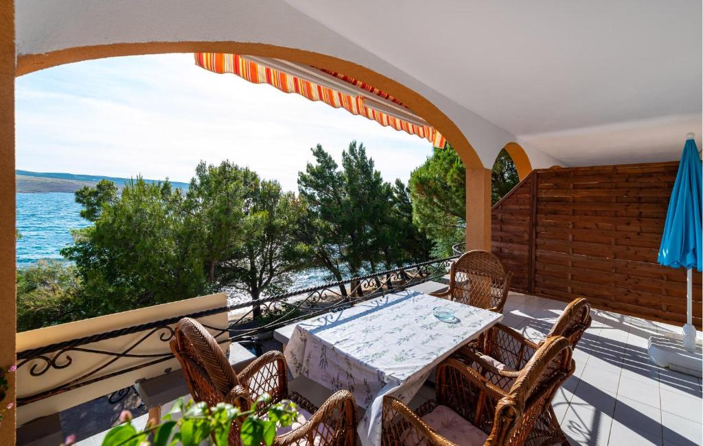 a table and chairs on a balcony with a view of the water at Beach Front Apartment In Rovanjska in Rovanjska