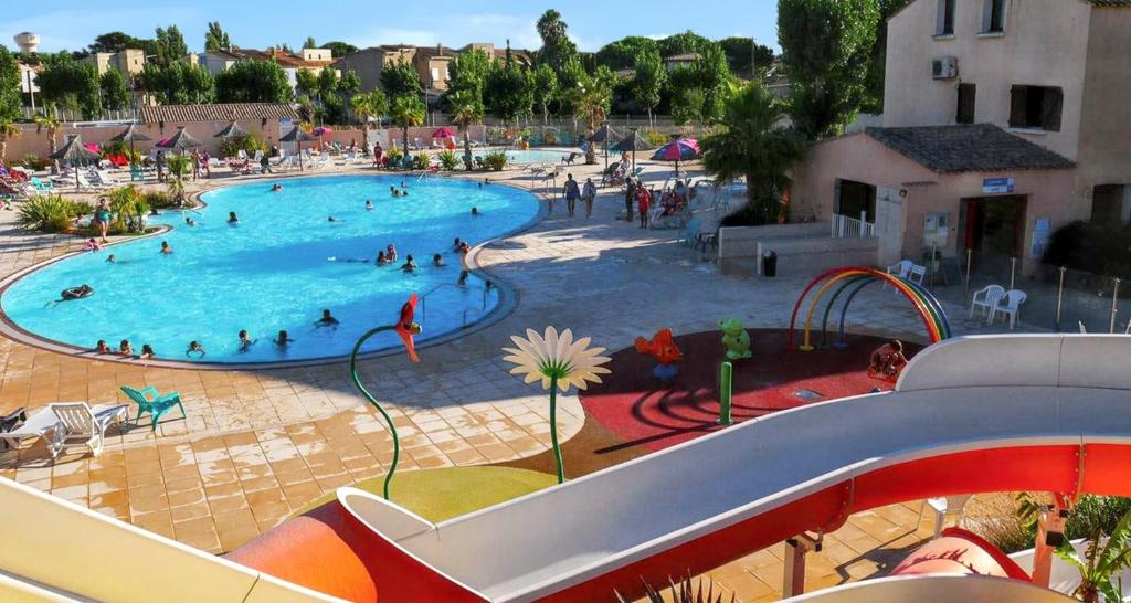 ein großer Swimmingpool mit Menschen darin in der Unterkunft Bungalow de 2 chambres a Valras Plage a 200 m de la plage avec piscine partagee et terrasse in Valras-Plage