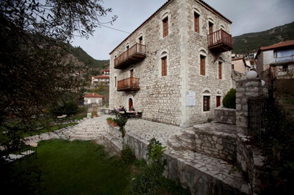 duży kamienny budynek z balkonem na górze w obiekcie Theoni's House w mieście Dhímitra