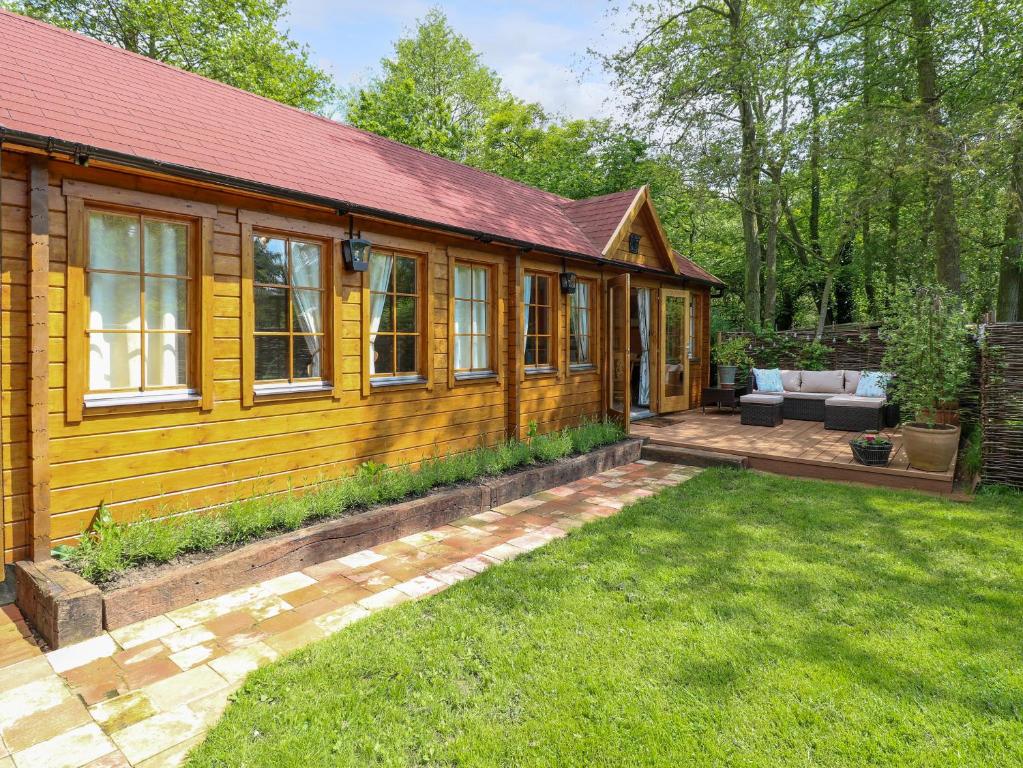 a wooden cabin with a patio and a yard at Willow Lodge in Great Yarmouth