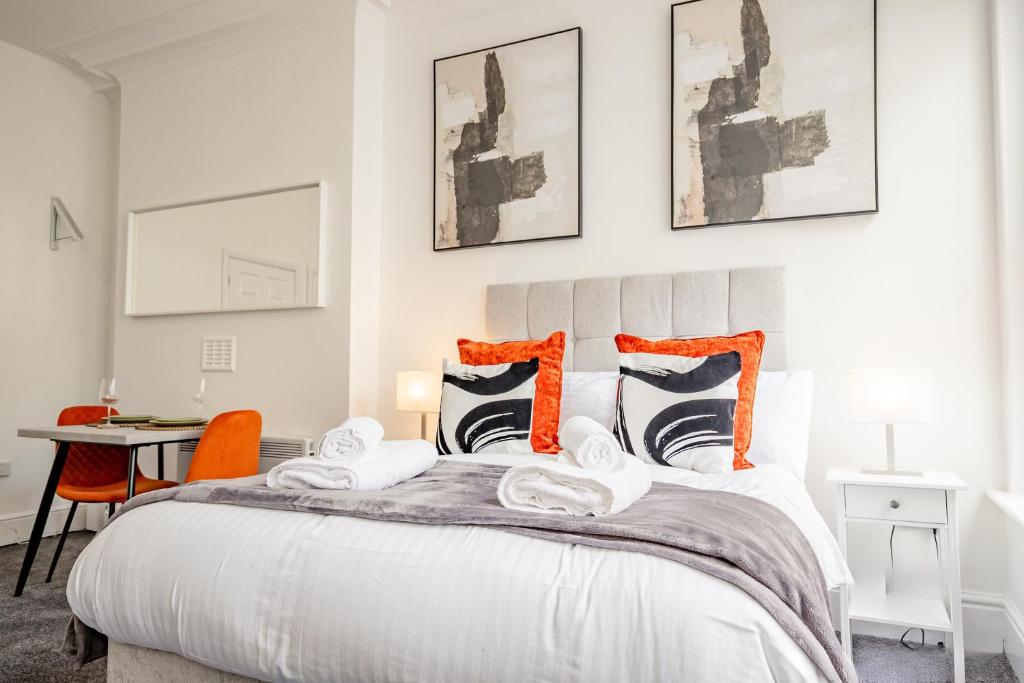 a bedroom with a large bed with orange accents at Guest Homes - The Station Studio in Worcester