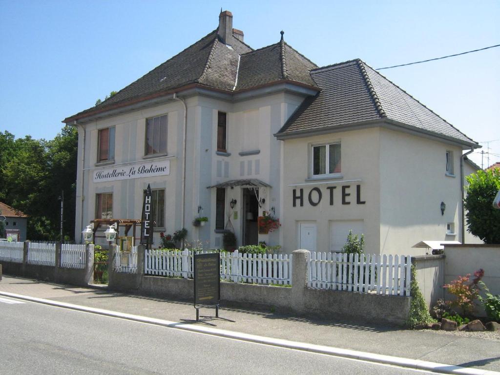 a white house with a white fence in front of it at Hostellerie La Boheme in Roppenheim