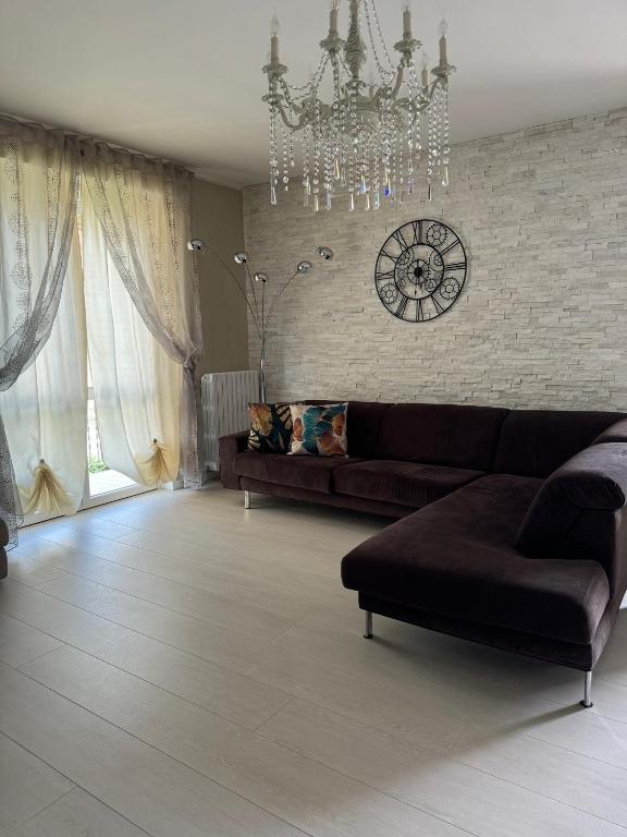 Una sala de estar con un sofá y un reloj en la pared. en Casa Nicole, en Montello