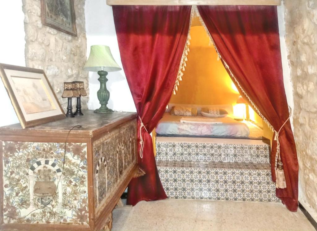 1 dormitorio con cama y cortina roja en One bedroom apartement with city view furnished terrace and wifi at Tunis en Túnez