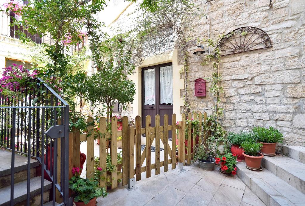 a wooden fence in front of a building with plants at Case del Vicolo Stretto in Modica
