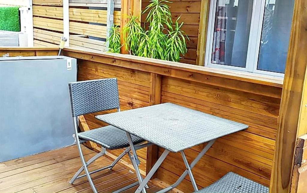 una mesa y dos sillas en un porche en Studio avec jardin et wifi a La Possession, en La Possession