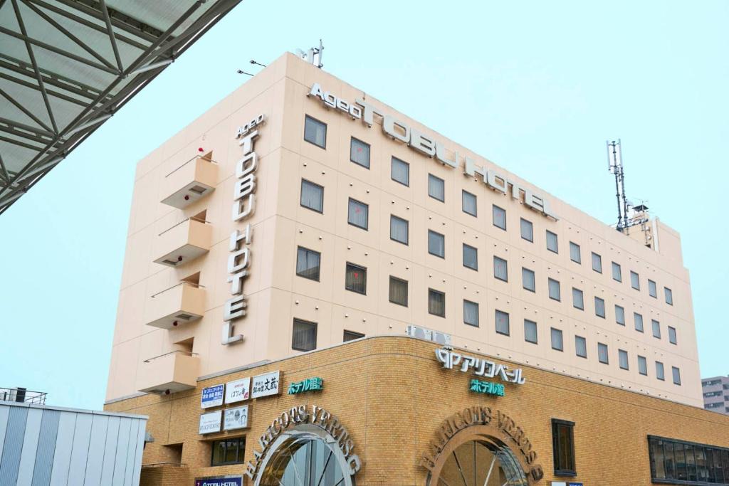 a large white building on top of a building at Ageo Tobu Hotel in Ageo