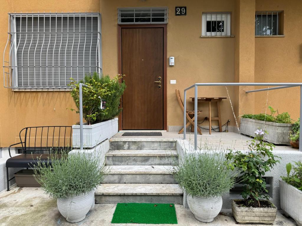 una puerta delantera de una casa con escaleras y macetas en Villetta Forlanini Milano en Milán