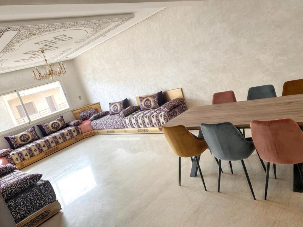 ein Wohnzimmer mit einem langen Tisch und Stühlen in der Unterkunft 2 bedrooms apartement with balcony at Nouaseur in Nouaseur