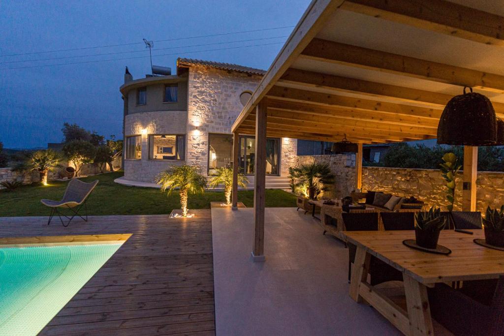 Un patio trasero con piscina y una casa. en Petra Luxury Villa, en Heraclión