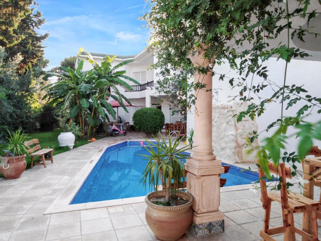 uma villa com uma piscina e uma casa em 4 bedrooms villa with private pool enclosed garden and wifi at Hammamet em Hammamet