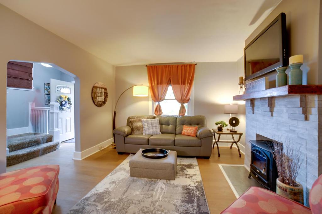 Una sala de estar con un sofá y una chimenea. en Pittsburgh Home with Private Yard 3 Mi to Dtwn!, en Pittsburgh